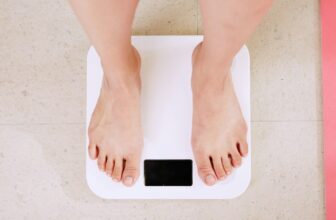 Person standing on a digital scale while tracking weight loss progress