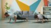 Two people doing push-ups on yoga mats during a short home workout