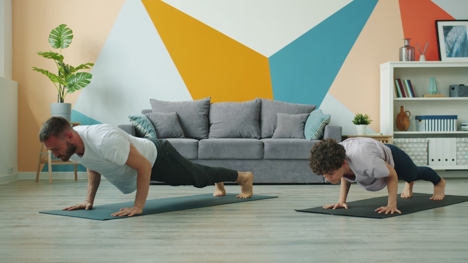 Two people doing push-ups on yoga mats during a short home workout