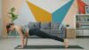 Woman doing a no-equipment plank workout on a yoga mat at home