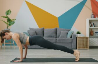 Woman doing a no-equipment plank workout on a yoga mat at home